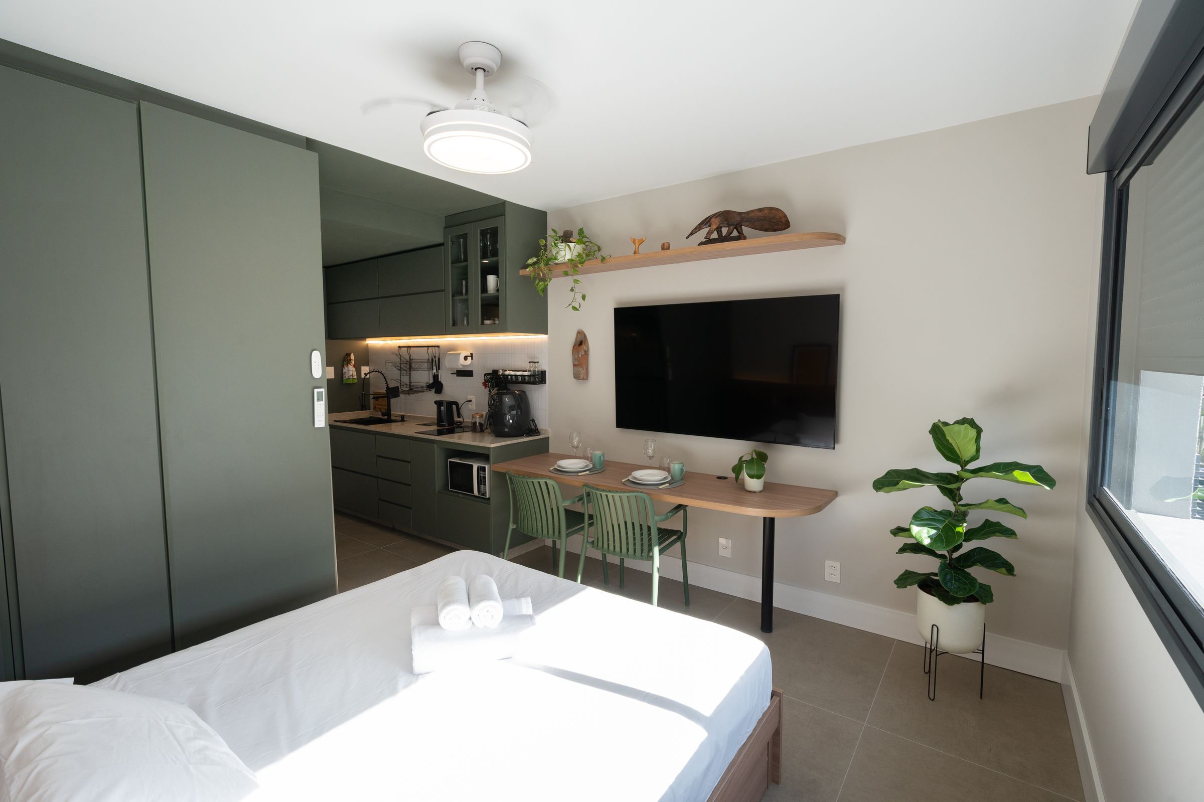 Studio 215 visto do armário, com cozinha, mesa de jantar e Smart TV